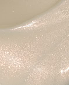 a close up view of the surface of a white bowl with gold flecks on it