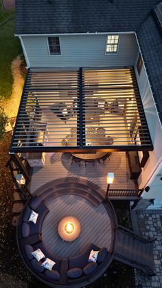 an aerial view of a patio and fire pit at night with lights on the deck