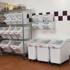 there are many bins and containers on the shelves next to each other in this room