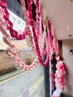 pink and red streamers hanging from the side of a building