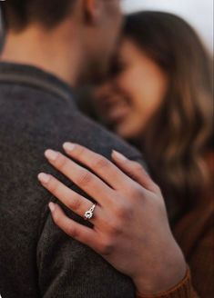 a man and woman embracing each other with their engagement ring