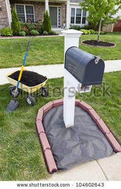 a mailbox and wheelbarrow in front of a suburban house stock photo - 957982