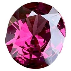 an oval shaped pink diamond with white and red highlights on the face, set against a white background