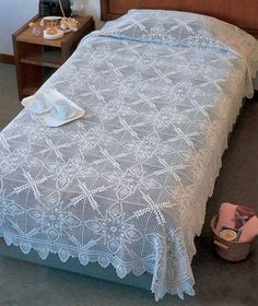 the bed is made with white lace on it