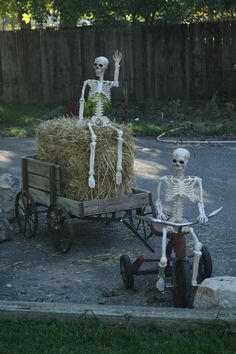 two skeletons are riding in a wagon with hay