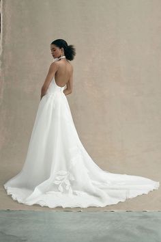 a woman in a white wedding dress standing back to back with her hand on her hip