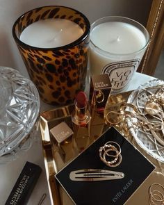 a table topped with candles and jewelry on top of a table next to a mirror