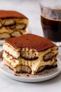 two pieces of cake sitting on top of a white plate next to a cup of coffee