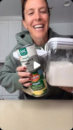 a woman holding a can of food in her hands