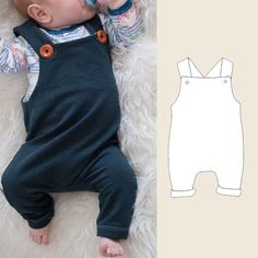 a baby laying on top of a white rug next to a paper cut out of a baby's body