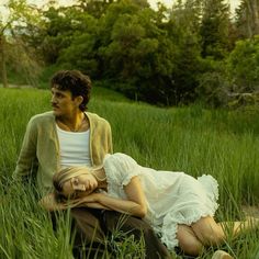 a man and woman sitting in tall grass