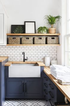 a washer and dryer in a small room with white tile on the walls