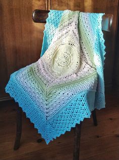 a crocheted blanket sitting on top of a wooden chair