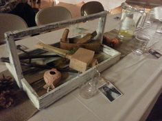 a table is set up with wine glasses, candles and other items in an old box