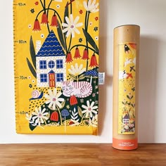 a wooden table topped with a tall vase next to a ruler