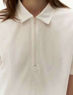 Introducing our timeless white polo shirt, a versatile and stylish addition to your wardrobe. This classic piece features a polo collar and a front zip fastening, offering a touch of sophistication to design. Create a variety of chic ensembles by pairing it with our faux-leather skirt for an edgy and fashion-forward look or with shorts for a casual and contemporary style. dusty pink color polo collar front zip fastening short sleeves straight ham Modern White Tops With Collared Neckline, Classic Cotton Half-zip Top, White Half-zip Cotton Top, White Cotton Half-zip Top, White Collared Neckline Tops For Everyday, White Collared Tops For Everyday, Dusty Pink Color, T Shirts White, White Polo Shirt