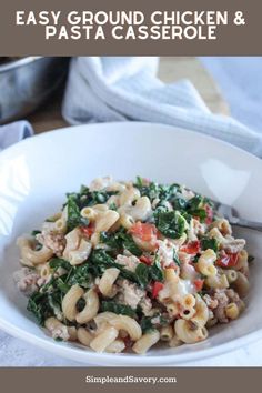 a white bowl filled with pasta and spinach