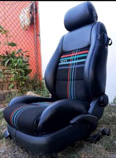 a black leather reclining chair sitting in the grass