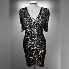 This Is A Brand New With Tags, Calvin Klein Sequined Evening/Party/Special Occasion Dress. The Bodice Crosses Overright Over Leftculminating At The Left Side In Gathers Which Fall Back Into Soft Folds Of A Left To Right Tulip Hem. The Sequins Are Sewn On To A Black Fabric. The Sequins Are Of A Metallic Gunmetal Color On One Side, And A Silvery Metallic Color On The Reverse. Ladies Size 10. Metallic V-neck Evening Dress, Fitted V-neck Sequin Dress For Festive Occasions, Shimmer V-neck Evening Dress For Party Season, Festive V-neck Evening Dress For Night Out, Glamorous Metallic Sequin Evening Dress, Glamorous Metallic Sequin Dress For Holidays, Glamorous Metallic Evening Dress With Sequins, Glamorous Metallic Sequin Dress For Holiday Party, Formal Fitted Sequin Dress With Shimmer