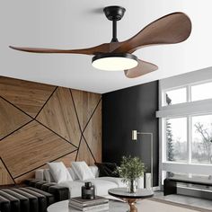 a living room with a couch, coffee table and ceiling fan in the middle of it