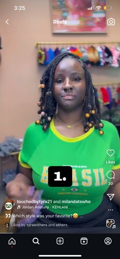 a woman with dreadlocks on her head and green shirt in front of a store