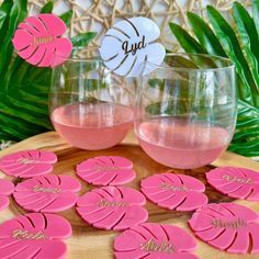 two glasses filled with pink liquid sitting on top of a wooden table next to each other