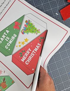 someone is cutting out christmas cards with scissors