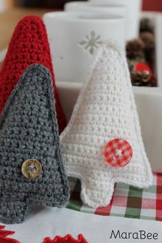 three crocheted christmas trees sitting next to each other on top of a table