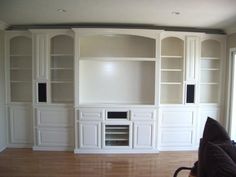 an empty living room with built in bookshelves