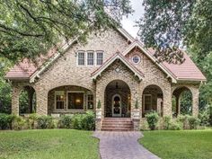 a brick and stone house with trees in the background