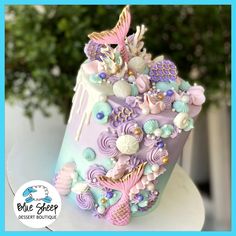 there is a cake decorated with mermaids and seashells