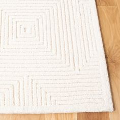 a white rug on the floor with wooden floors