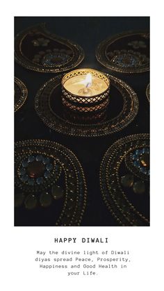 a lit candle sitting on top of a table next to other plates and bowls with words that say happy diwali