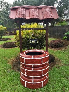 a large red brick planter sitting in the grass