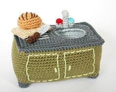 a crocheted box with a snail on top and a sink in the middle