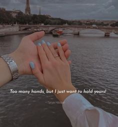 two people holding hands over the water with a bridge in the background that says, too many hands, but i just want to hold yours