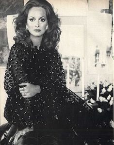 a black and white photo of a woman sitting on a chair with her arms crossed