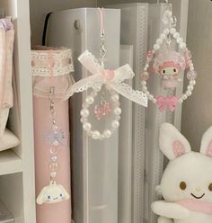 a white stuffed animal sitting next to a pink and white object on a shelf in a closet