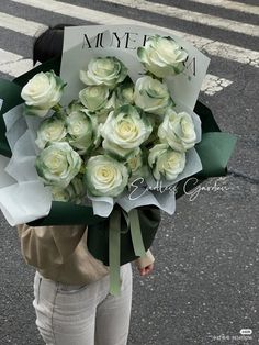 a woman holding a bouquet of white roses