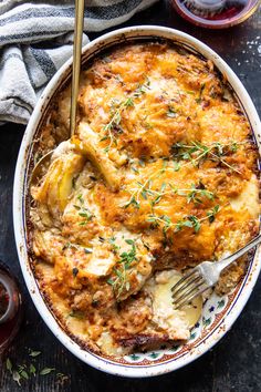 a casserole dish with chicken, potatoes and herbs in it on a table