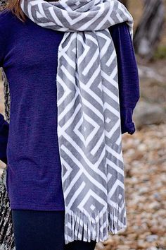 a woman standing next to a tree wearing a scarf