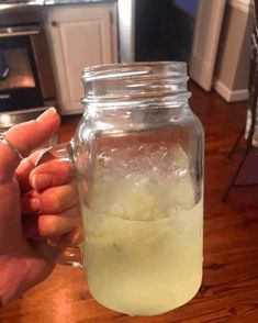 a person holding a mason jar filled with ice