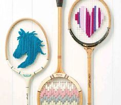 two different types of tennis rackets are hanging on the wall, one with a horse head