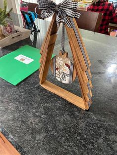 an ornament hanging from the side of a wooden triangle on top of a counter