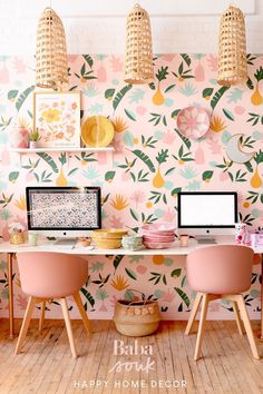 two desks with computers on top of them in front of a wallpapered background