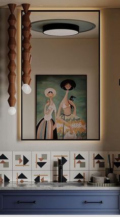 a bathroom with blue cabinets and artwork on the wall, along with an art deco light fixture