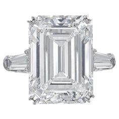 Elevate your style with this exquisite ring, a true embodiment of sophistication and elegance. At its heart, a resplendent 5-carat emerald-cut diamond takes center stage, displaying the enchanting interplay of light and facets. With a subtle I color and exceptional VS2 clarity, the diamond emanates a timeless beauty that captivates the senses. Flanking the majestic emerald-cut diamond are two tapered baguette diamonds, adding a touch of contemporary flair to the classic design. These diamonds co Harry Winston Diamond, Emerald Cut Diamond Engagement, Contemporary Engagement Rings, Emerald Cut Diamond Ring, Dream Party, Baguette Diamond Rings, Platinum Diamond Rings, Modern Engagement Rings, Bracelet Love