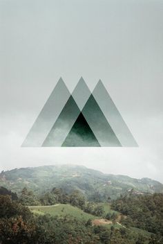 the mountains are covered in trees and grass, with one triangle above them that is black and white