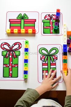 a child is playing with legos and building blocks to decorate christmas presents on the wall