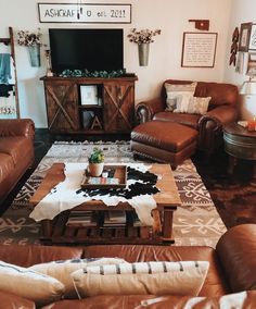 a living room filled with brown leather furniture